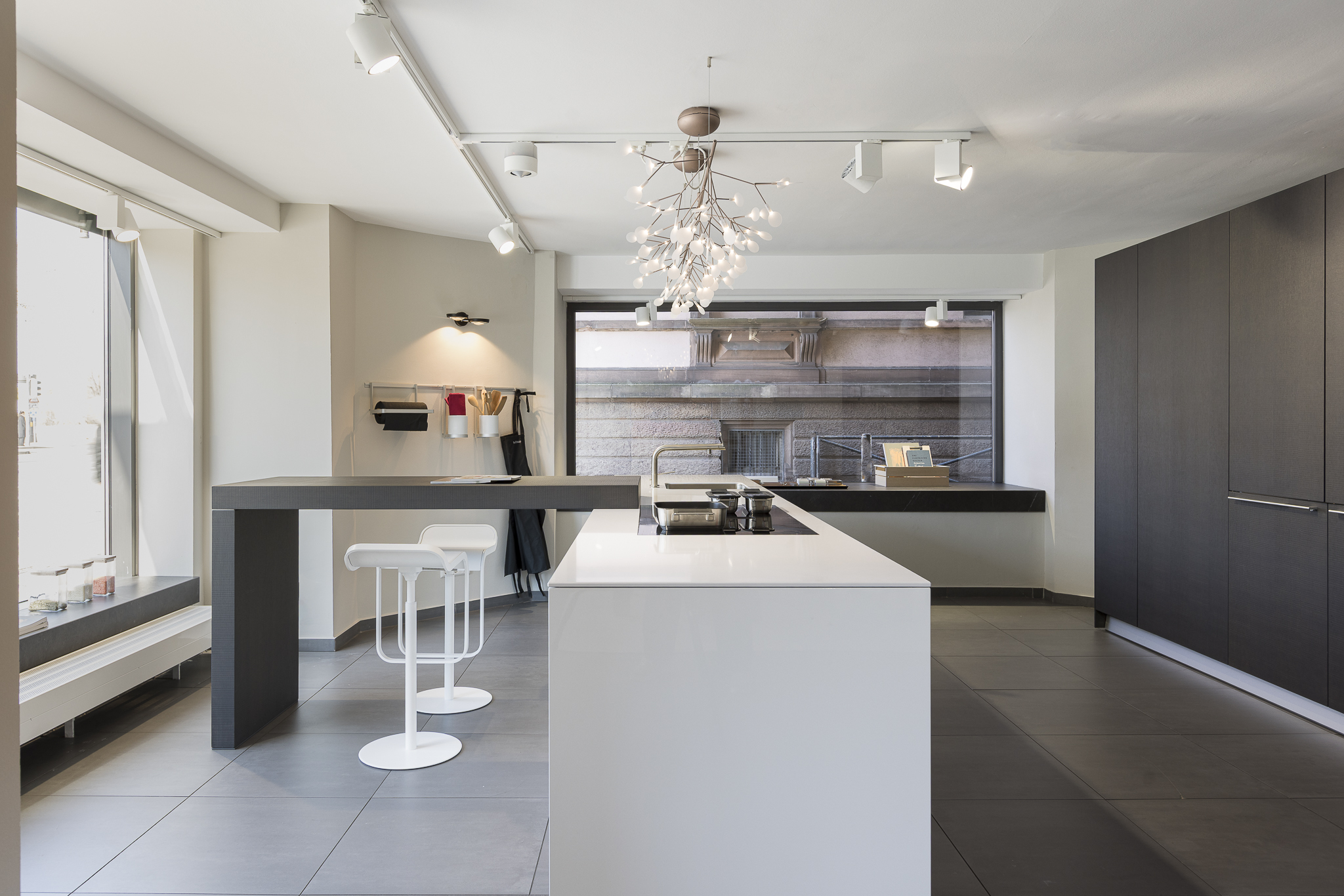 Weiße Kücheninsel mit schwarzer Barplatte im Bulthaup Showroom Heidelberg – Küchenplanung und Design