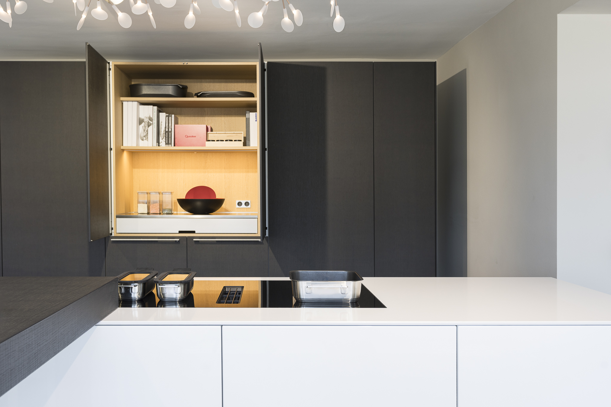Pocketdoor, Drehschiebetür Geöffneter Küchenschrank b3 mit Beleuchtung im Bulthaup Küchenstudio Heidelberg – elegantes Innenraumkonzept