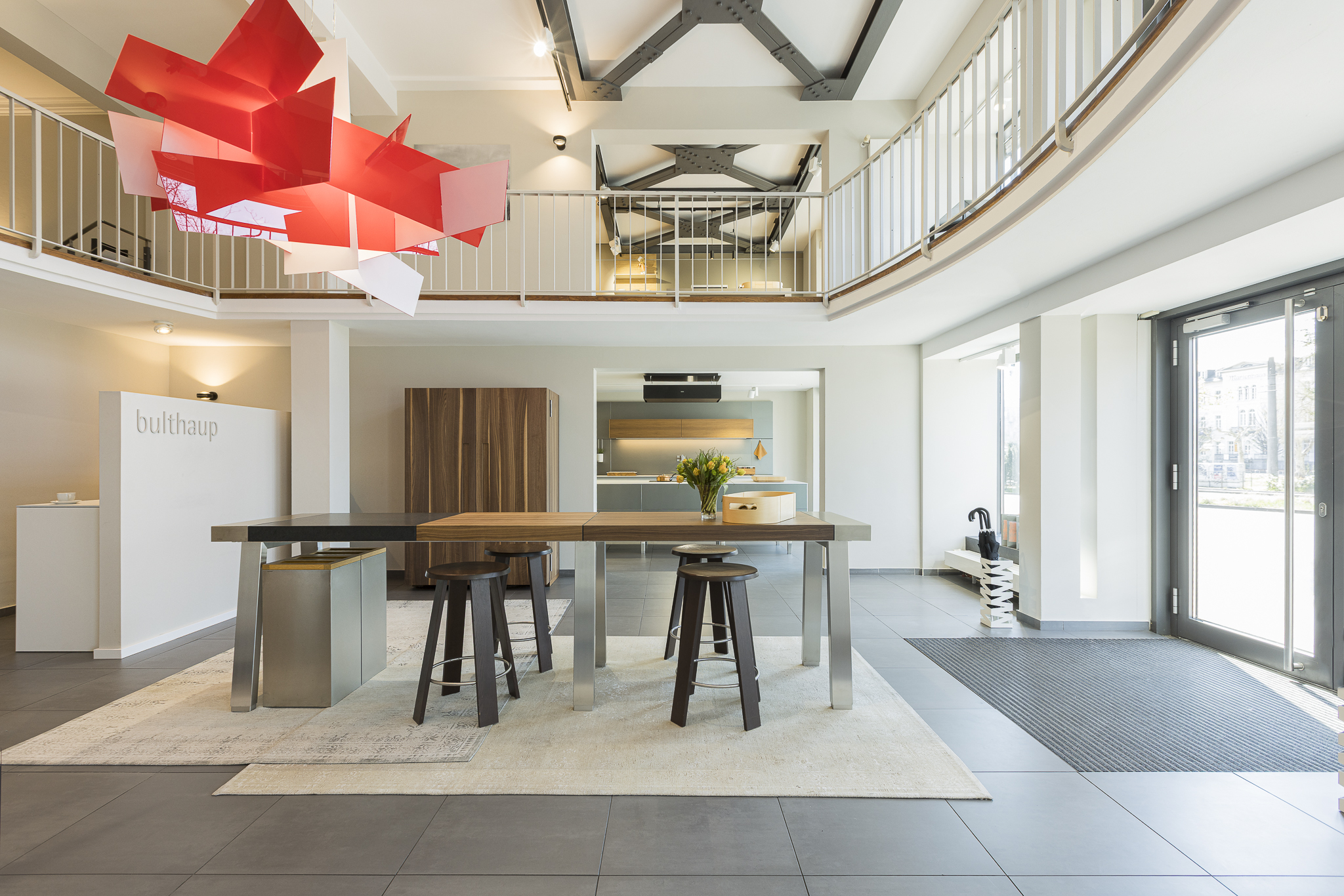 Showroomansicht mit Galeriegeschoss und Holztisch b2 – Küchenarchitektur bei Bulthaup Heidelberg